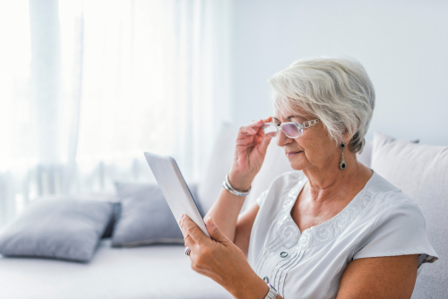 Elderly woman with cataracts attempting to read
