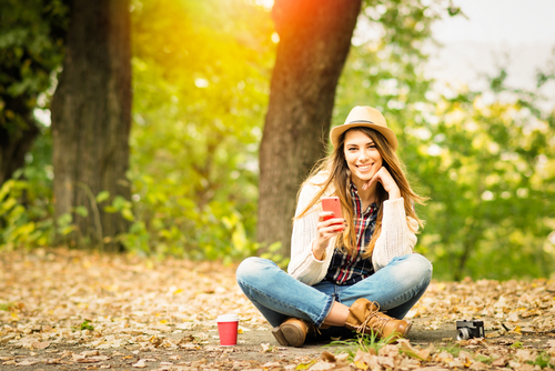 girl sitting on trail taking picture 