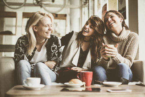 3 women laughing on couch 