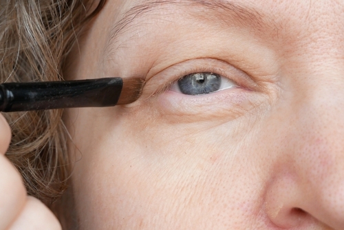 woman applying makeup around eyes